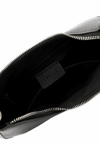 Černá kožená taška s texturovaným povrchem, která má stříbrný zip a černě podšitou vnitřní část s malou koženou etiketou.