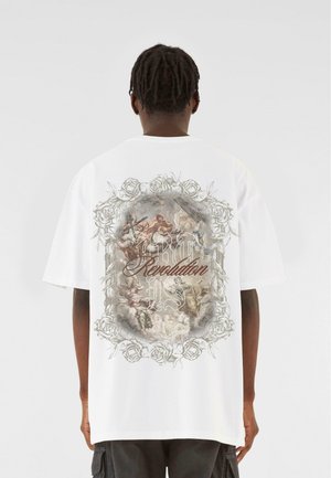 Hvid oversized bomulds t-shirt med et detaljeret grafisk print på ryggen, omgivet af rosemotiver og ordet "Revolution" i stiliseret tekst.