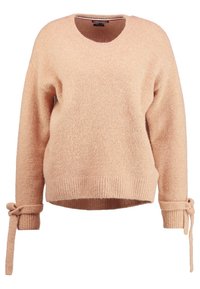 Ljust persikofärgad fluffig tröja med rund halsringning, ribbad detalj och knytningar vid ärmarna. Mjuk textur och avslappnad passform.