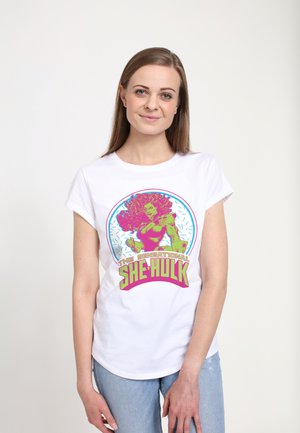 Hvid bomulds t-shirt med et farverigt grafik af She-Hulk og fed tekst nedenfor. Korte ærmer og en afslappet pasform er synlige.