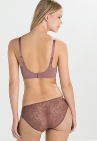 Mauve-BH mit verstellbaren Trägern und Hakenverschluss, kombiniert mit blumenmusterhaften, durchsichtigen Slips. Glattes Material mit weicher Textur.
