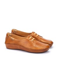 Zapatos marrones de piel tipo mocasín con costuras decorativas, puntera redonda y dos tiras de acento en la parte frontal. Textura suave y diseño de bajo perfil.