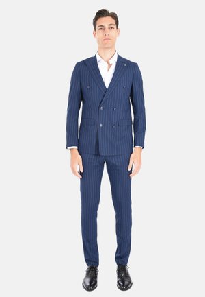 Abito blu a righe con giacca doppiopetto, pantaloni slim-fit e scarpe in pelle nere. Tessuto liscio e design su misura.