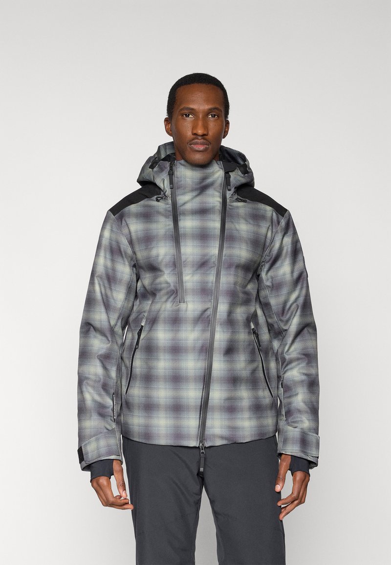 Chaqueta de cuadros para hombre en tonos gris y verde con capucha, con detalles negros en los hombros, bolsillos con cremallera y superficie texturizada.