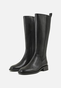 Botas de couro pretas até ao joelho com um acabamento liso, fecho lateral e um salto baixo em bloco. Inclui painéis elásticos para maior flexibilidade e conforto.