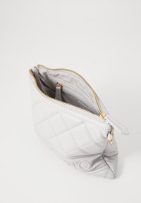 Bolso de couro cinza matelassado com um zíper dourado, apresentando um bolso interior e uma textura suave. A base tem detalhes em relevo.