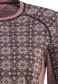 Langarmshirt mit einem pinken und grauen geometrischen Muster sowie schwarzen Akzenten. Weicher Stoff mit rundem Ausschnitt und kontrastierenden Nähten.
