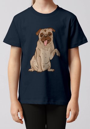 Enfant portant un t-shirt bleu marine arborant un carlin dessin animé assis avec une patte levée et la langue tirée.