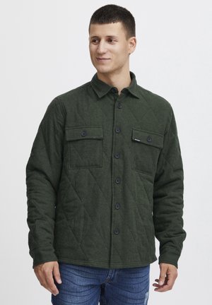 Green quilted shirt jacket made of textured fabric, featuring a collared neck, front buttons, and two chest pockets.