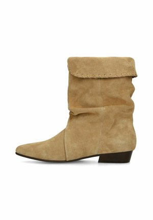 Beige suede mid-calf slouchy boot with folded top and low stacked heel, shown in side profile on a white background.