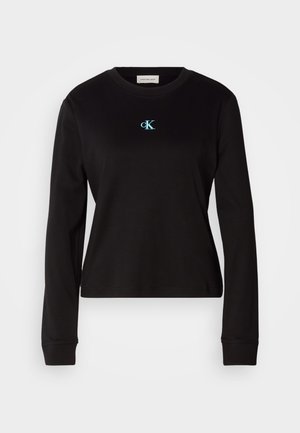 Svart langermet t-skjorte laget av bomull med rund hals. Har et lyseblått brodert logo "cK" på brystet. Slim fit design.