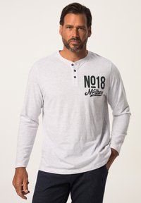 Grå langærmet henley-skjorte med tre sorte knapper ved halsen. Har "NO18 Northern" trykt i mørkegrøn på fronten.
