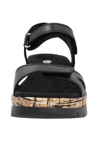 Sandale noire avec des straps réglables, semelle intermédiaire en liège avec un motif texturé et un chaussant noir doux pour le confort.