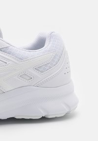 Scarpa da ginnastica bianca con tomaia in mesh testurizzato, collo imbottito e suola ammortizzata con accenti sottili e perforazioni per la traspirabilità.