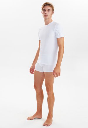Hvid kortærmet t-shirt og matchende boxershorts lavet af et glat, strækbart stof, med en rund halsudskæring og en tætsiddende pasform.