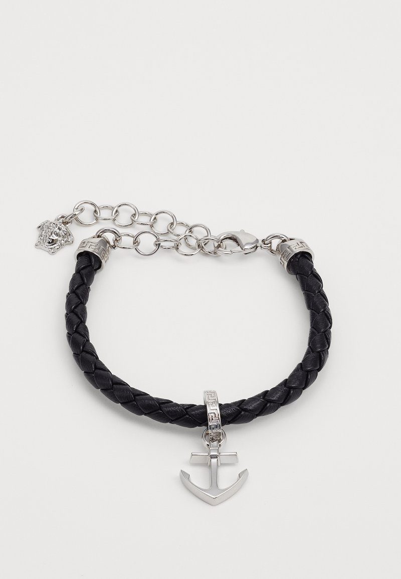 Bracelet en cuir tressé noir avec breloque ancre en argent et fermoir chaîne en argent avec un petit détail tête de lion.