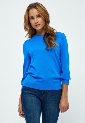 Bright blue knitted sweater with a round neckline, three-quarter sleeves, and ribbed hem, paired with dark blue jeans.