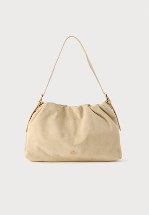Sac à main en cuir suédé beige avec un design froncé, une bandoulière unique et des détails en métal doré. Texture douce et forme non structurée.