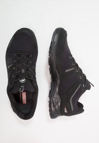Czarne buty trekkingowe wykonane z materiału syntetycznego, z teksturowanymi powierzchniami, gumowymi podeszwami i metaliczno-szarymi akcentami. Posiadają sznurowaną konstrukcję.