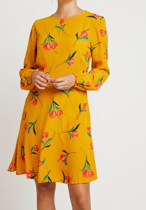 Geel jurk met lange mouwen en bloemenprint in roze en groen. Voorzien van een ronde hals, geplooide manchetten en een vloeiende rokkenzoom.