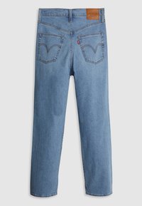 Jean en denim bleu avec deux poches arrière avec couture signature et une petite étiquette de marque en cuir marron sur la ceinture.