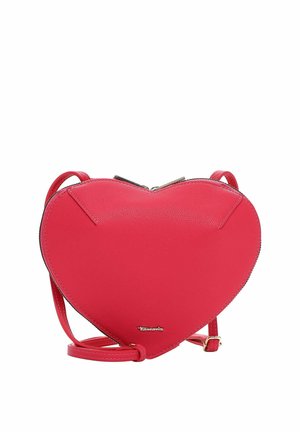 Červená kabelka přes rameno ve tvaru srdce z kůže, s horním zipem a nastavitelným popruhem, malým kovovým logem značky blízko spodního středu.