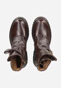 Bottes en cuir marron au design flou, à bouts ronds et à semelle épaisse. Présente des accents en matériel doré et une doublure intérieure confortable.