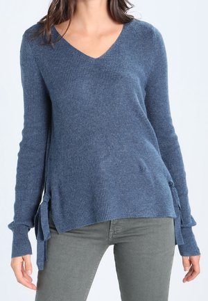 Blauer, gerippter V-Ausschnitt-Pullover mit seitlichen Bindebändern, langen Ärmeln und lockerer Passform. Der Stoff wirkt weich mit einer dezenten Textur, geeignet für die Freizeit.