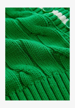 Zelená pletená tkanina s textúrovanými vzormi, obsahujúca rebrované časti a hladké plochy, doplnená zelenými gombíkmi a krémovými pruhmi.