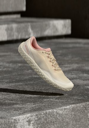 Light beige and pink Merrell sneaker with textured sole, laces, and breathable mesh fabric, angled above concrete stairs.