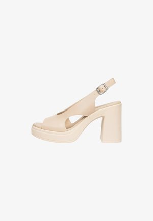 Sandalo slingback beige con tacco alto, punta aperta, lati ritagliati, suola platform e cinturino regolabile con fibbia argento.