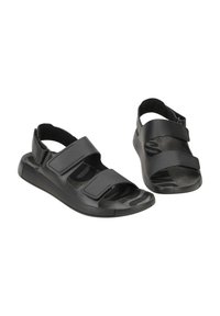 Schwarze Sandalen mit verstellbaren Klettverschlüssen, einem strukturierten Fußbett mit Wellenmuster und einer robusten Gummisohle.