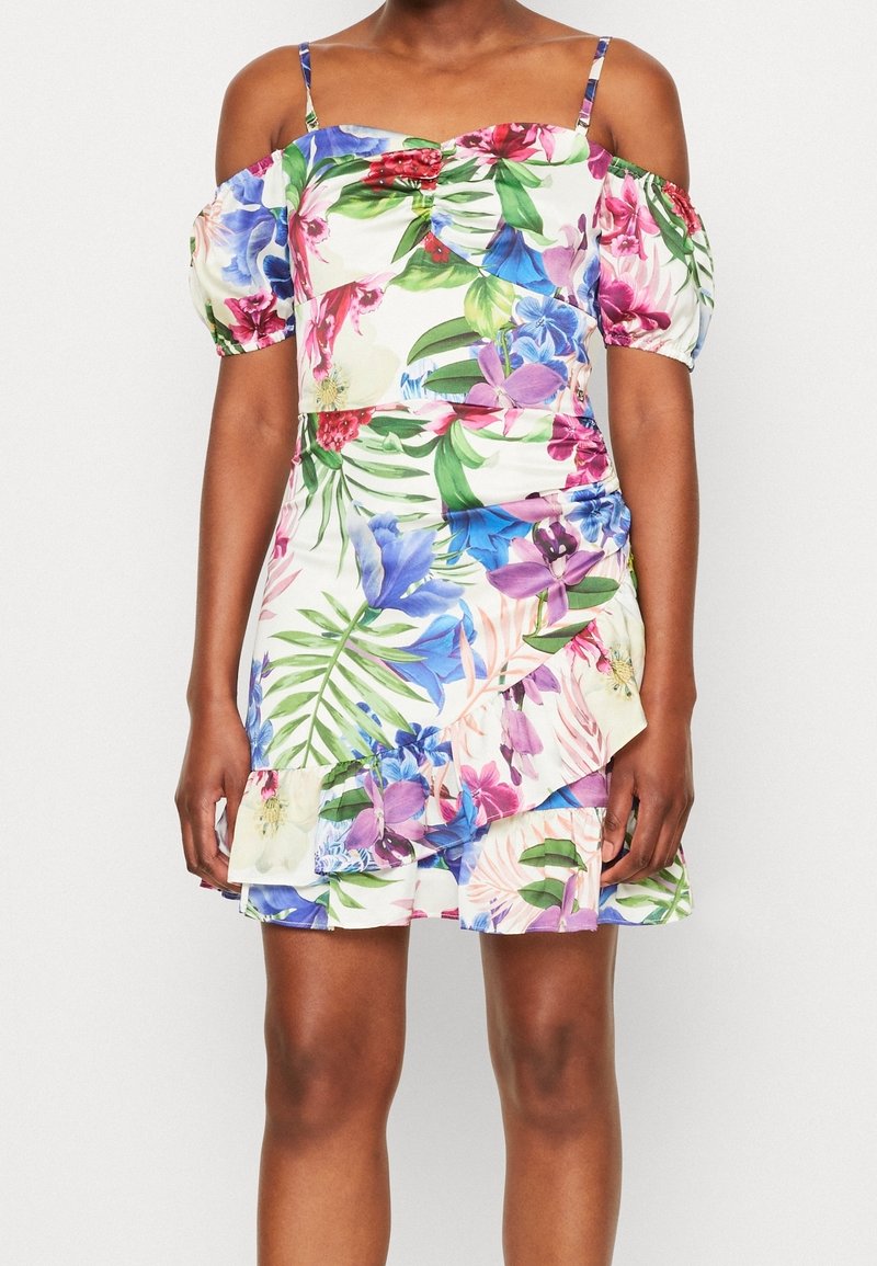 Robe fleurie à épaules dénudées avec manches bouffantes, ourlet à volants et mélange de motifs floraux tropicaux rose, bleu, vert et violet.