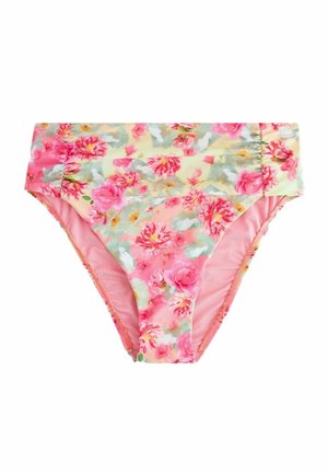 Detail ružovej látky s kvetinovým vzorom s červenými, bielymi a zelenými kvetmi, nosenej v páse, zobrazujúci malú zlatú značkovú tabuľku.