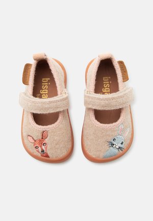 Chaussures beige clair pour tout-petits avec bandes Velcro, avec un cerf brodé sur la chaussure gauche et un lapin sur la droite, semelles marron.