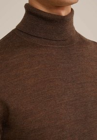 Brah turtleneck pulover iz mehkega, finoknit materiala z gladko teksturo in prilegajočim se dizajnom okoli vratu.