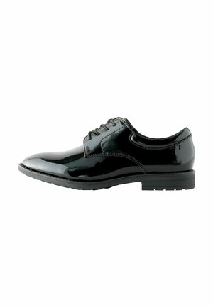 Zapato oxford de cuero negro con un acabado brillante, diseño de cordones, punta redondeada y suela de goma baja con un dibujo en relieve.