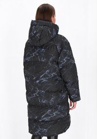 Schwarze Pufferjacke mit blauem Marmor-Muster, ausgestattet mit einer Kapuze, langen Ärmeln und einem gesteppten Design mit einer leicht strukturierten Oberfläche.