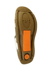 Sko sål med et brun genbrugsmateriale, tekstureret overflade, orange label med tekst og hvide stropper langs siden.