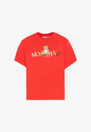 Czerwona koszulka z krótkim rękawem z kolorowym napisem "MOSCHINO" i grafiką siedzącego misia na środku klatki piersiowej.