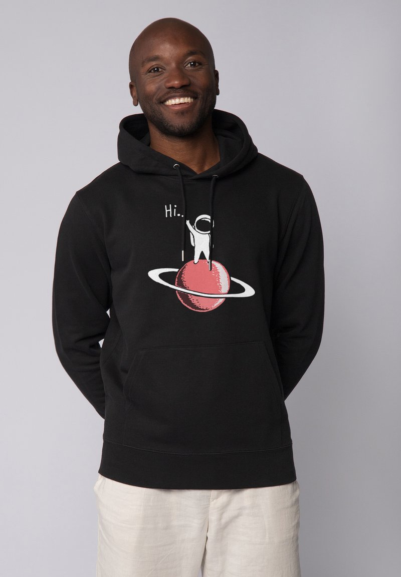 Zwarte hoodie met een grafisch ontwerp van een kleine astronaut op een rode planeet met ringen. Gemaakt van zacht materiaal met een frontzak en een verstelbare kap.