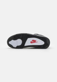 Nike-såle med svart gummi, hvit mellomsåle og rød logo. Har et teksturert mønster for grep og buet design for fotstøtte.