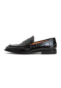 Svarta läderloafers med en slät yta, försedda med ett dekorativt band och låg gummihäl. Sleek design med rundad tå.