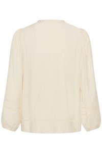 Blouse ample crème à manches longues avec manches bouffantes et bordure en dentelle sur les manches et l'ourlet, vue de dos.