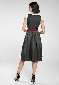 Grijze jurk met een nauwsluitend lijfje, gerimpelde mouwen en een bordeauxrode tailleband. De rok heeft een structuur met een ruitpatroon en plooien.