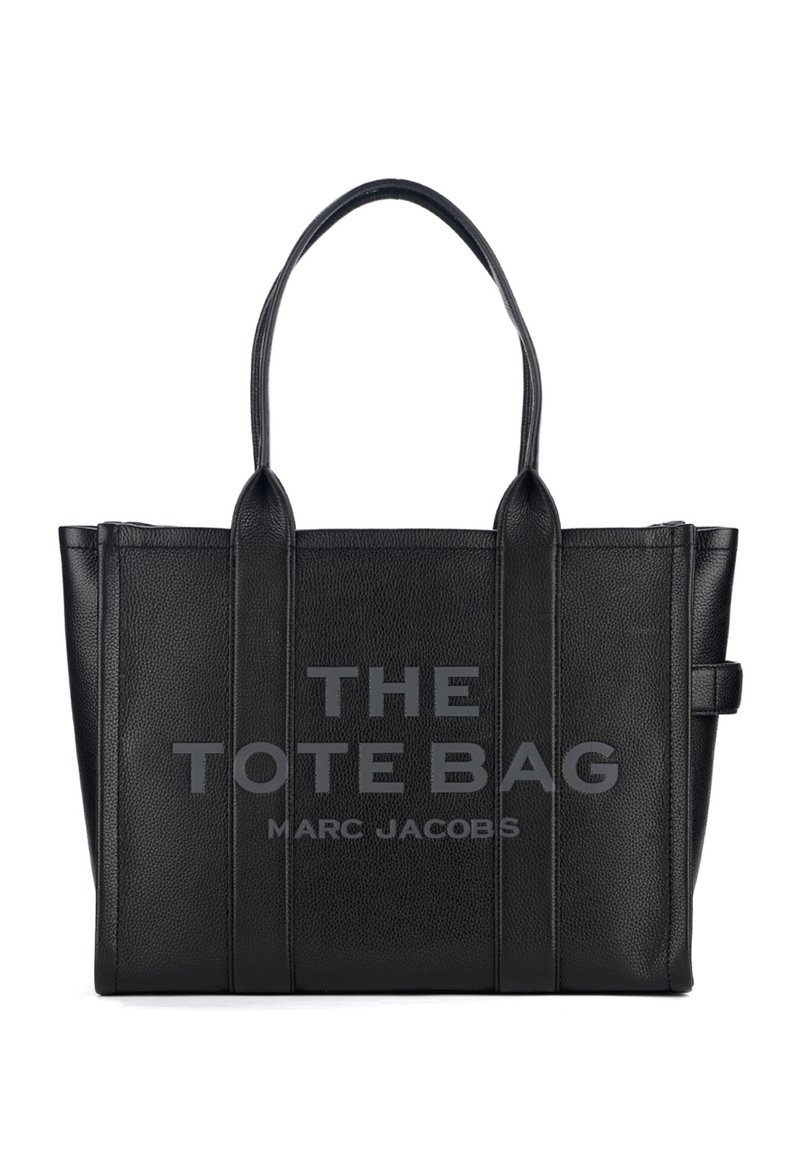 Must mustrassak, mille käepidemega ja reljeefse tekstiga "THE TOTE BAG MARC JACOBS" esiküljel.