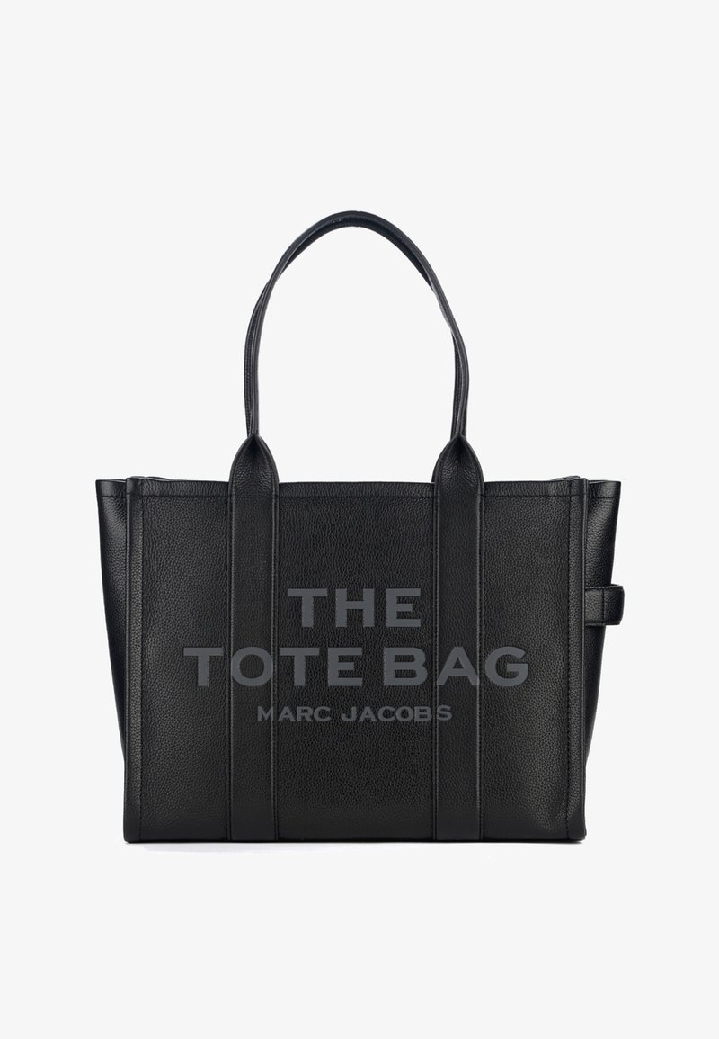 Saco tote de pele preta com duas alças e texto em relevo "THE TOTE BAG MARC JACOBS" no painel da frente.