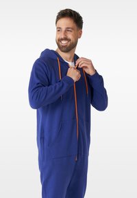 Blue hoodie jumpsuit with orange drawstrings. Features a front pocket and a zip closure. Made of soft, textured fabric.