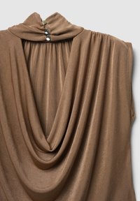 Haut drapé marron avec un col montant et une fermeture par boutons, en tissu doux et texturé créant une silhouette élégante.