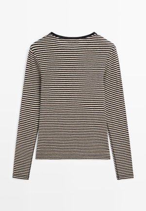 Langærmet top med sort og cremefarvet stribet mønster, rund halsudskæring, blød strikket tekstur, tætsiddende pasform og sidesømme med subtile syningsdetaljer.